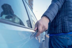 guy scratching a car door with a screwdriver