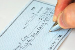 A person is writing a check out for more than $1,000.