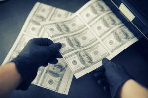 gloved hands holing forged money