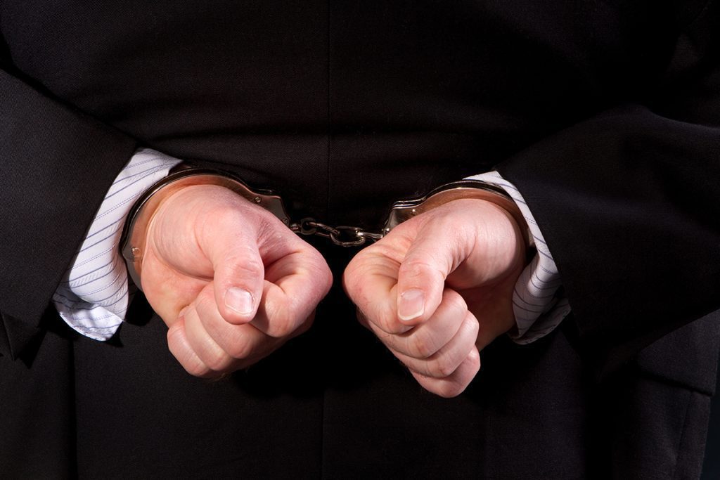 hands behind someone’s back, handcuffed