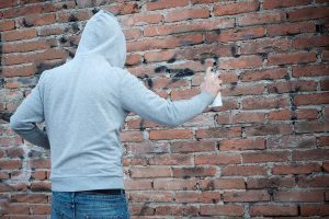 Man writing graffiti on the urban walls
