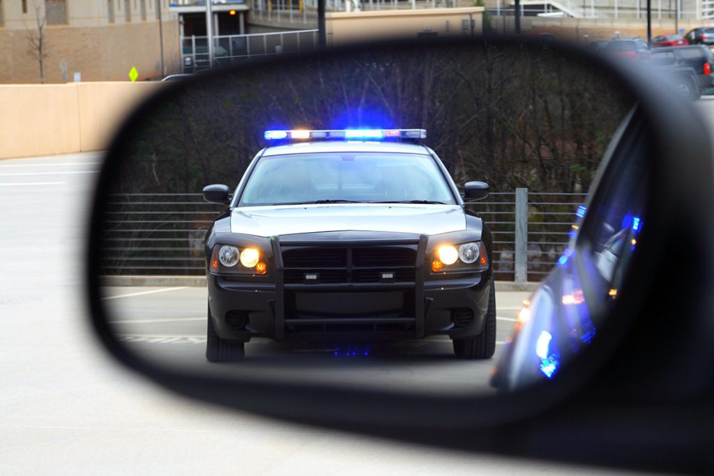 an image of a police car in a vehicle’s side mirror
