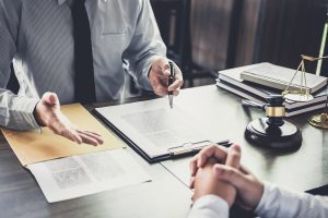 A lawyer sits at his desk and meets with a client.