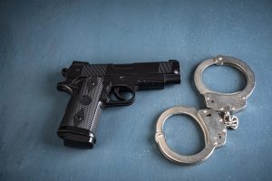 A handgun and a pair of handcuffs on a table